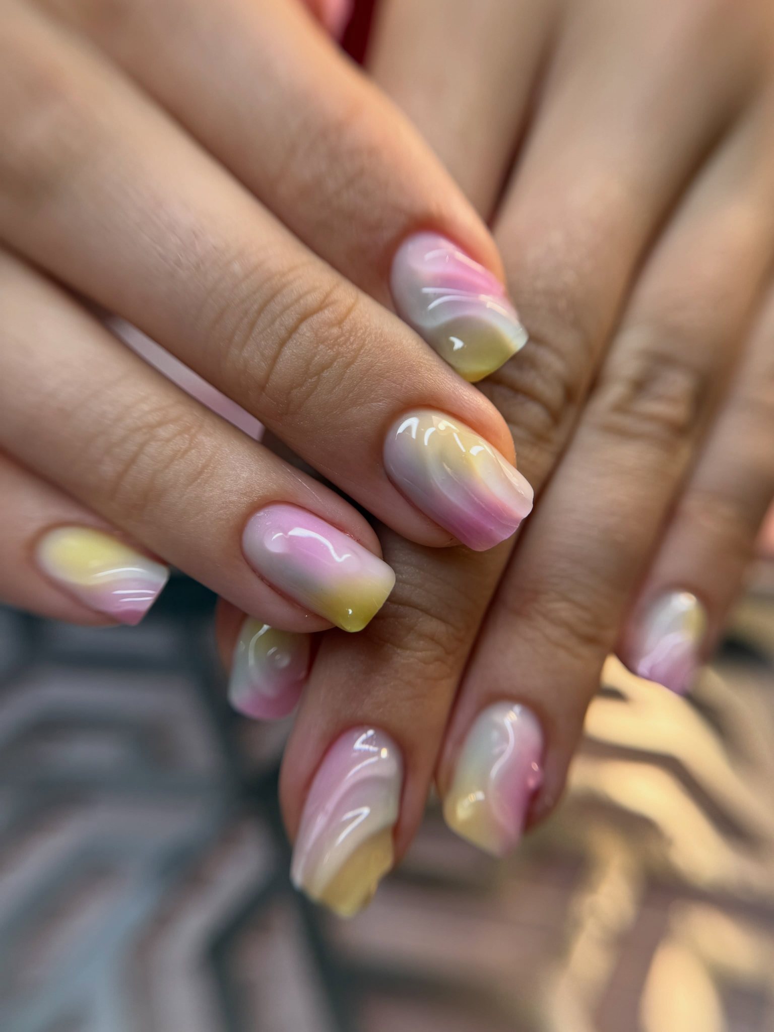 Pastel aura-nagels in roze, geel en blauw