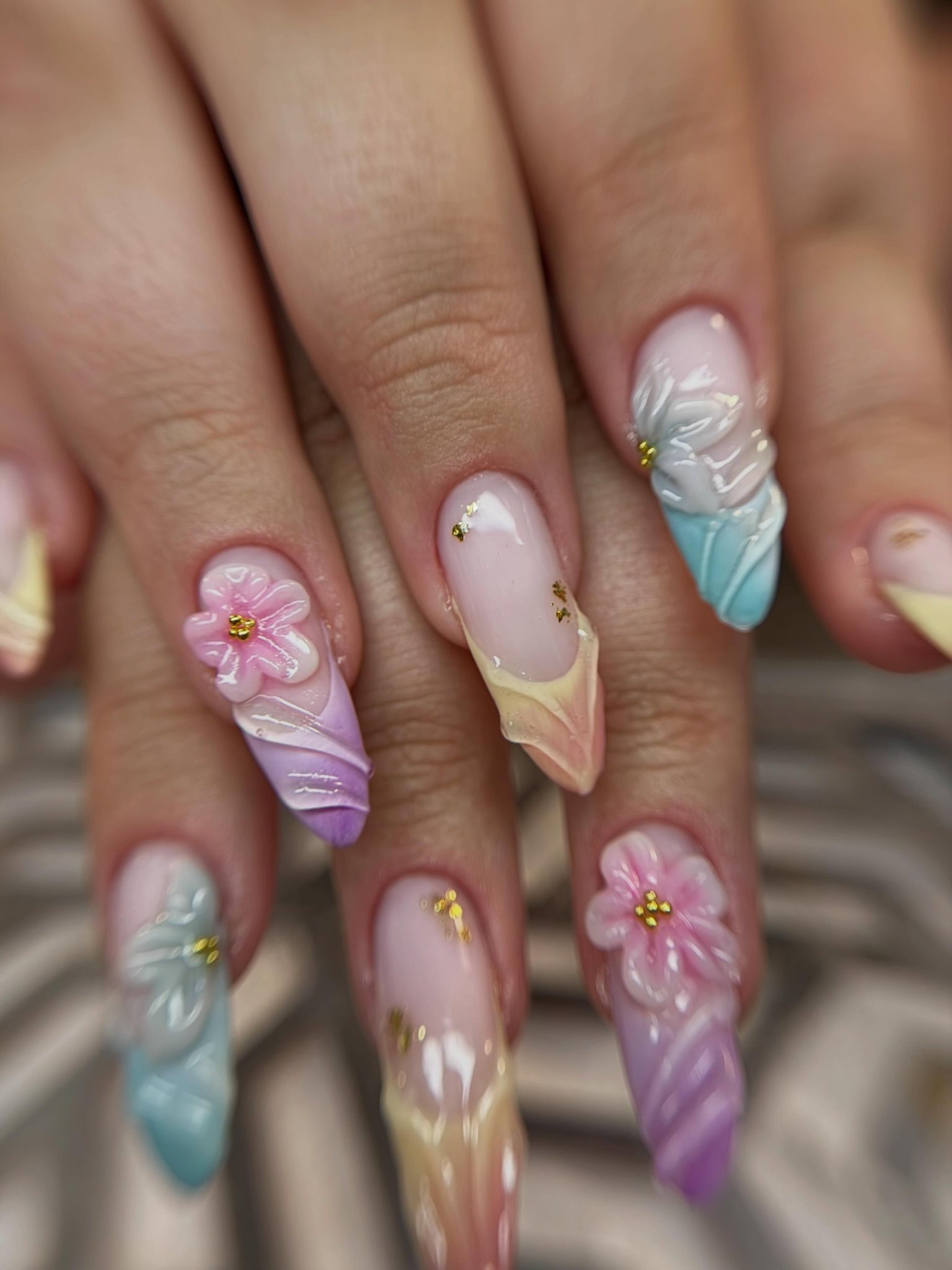 Pastel amandelnagels met 3D-bloemetjes en goudaccenten